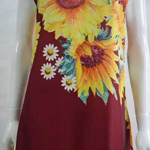 Detailed view of the vibrant sunflower pattern on a red bohemian summer maxi dress.