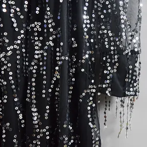 Detailed macro shot of black mesh fabric with silver sequins and fringe tassels