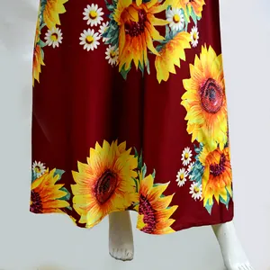Detail view of Bohemian sunflower and daisy print on dark red summer maxi dress.