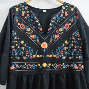 Vue détaillée de l'imprimé floral ethnique bohème sur une robe noire à col en V fluide