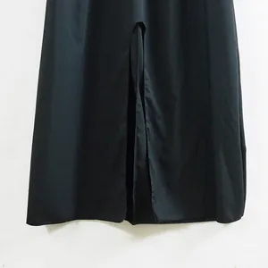 Gros plan détaillé sur l'élégante fente avant de l'ourlet d'une robe noire évasée