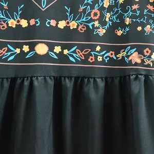 Détail de l'imprimé floral ethnique et de la couture plissée sur une robe trapèze bohème noire