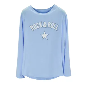 Detalle de una camiseta azul de manga larga con estampado Rock & Roll y pedrería brillante