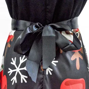 Detalle de un vestido navideño vintage con un lazo de satén negro y un estampado de copos
