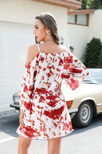 Rear view of a red and white tie-dye cold-shoulder vacation dress with elastic waist