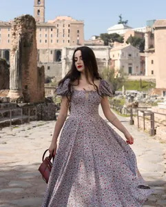 Elegant vintage floral maxi dress with puff sleeves captured in a historic outdoor setting