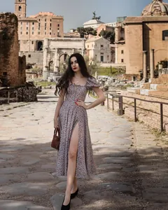 Elegant floral midi dress with puff sleeves and high slit worn in a scenic outdoor setting
