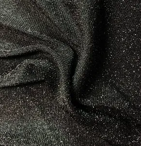 Primo piano di tessuto nero glitterato con trama scintillante e struttura a maglia fitta