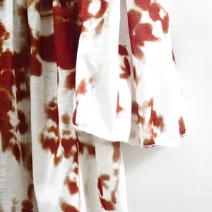 Macro view showing the detailed texture and red tie-dye print of this summer vacation dress
