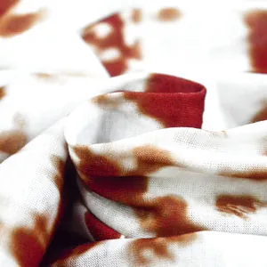 Macro detail view of the breathable white and brown tie-dye print fabric for summer dress