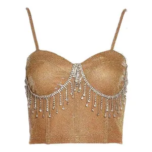 Detalle del tejido dorado brillante y los flecos de pedrería en el top tipo bustier.