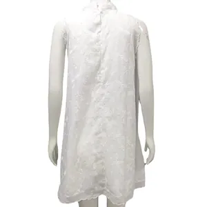Vista posteriore del vestito bianco senza maniche con ricami floreali e bordo smerlato.