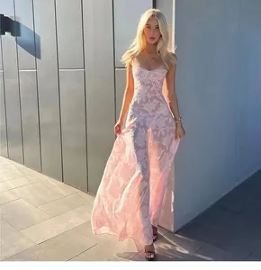 Elegantes langes Kleid mit Blumenmuster in Rosa, getragen von einem Modell im Sonnenlicht