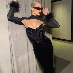 Detailed view of an elegant black velvet corset dress with mesh and feather cuffs