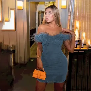 Sexy off-shoulder denim dress with feather trim shown in a lifestyle indoor setting