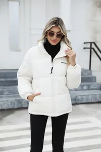 Close-up front view of a women's white winter puffer jacket with a stand collar