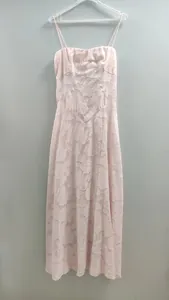 Detailansicht eines rosa Maxikleides mit Blumenstruktur und transparenten Stoffdetails.