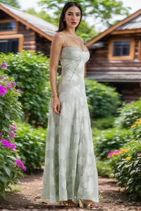 Elegantes hellgrünes Maxi-Blumenkleid mit Spaghettiträgern in einer malerischen Gartenumgebung