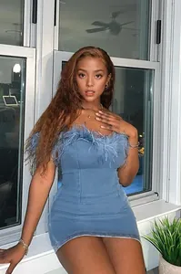 Detailed view of a stylish blue denim bodycon mini dress with elegant feather trim accents
