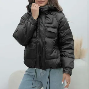 Detailed view of women's thick black hooded puffer jacket with pocket detail