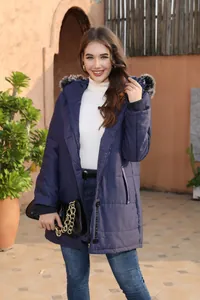 Stylish navy blue hooded winter parka with fur trim for women in an outdoor setting