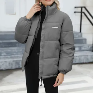 Detail view of a grey stand-collar puffer jacket for women in a winter outdoor setting