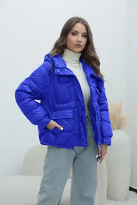 Front view of woman wearing thick electric blue puffer jacket with hood for winter