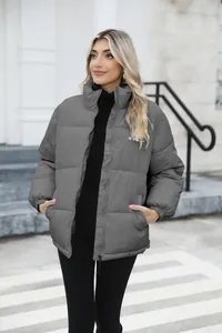 Warm grey puffer jacket for women styled with a black turtleneck in urban setting.