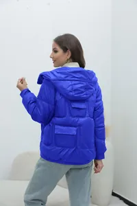 Back view of a vibrant bright blue hooded puffer jacket for women in a studio setting