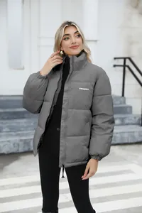 Detail of the grey quilted winter puffer jacket with high collar and front zipper closure.