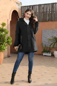 Woman wearing a stylish black mid-length hooded puffer coat in an outdoor lifestyle setting