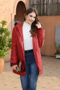 Elegant woman wearing a red mid-length hooded winter padded jacket with faux fur trim outdoors