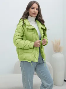 Detail view of a bright lime green quilted puffer jacket with hood and drawstring hem