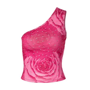 Detailweergave van de felroze one-shoulder top met rozenprint en fonkelende strassteentjes