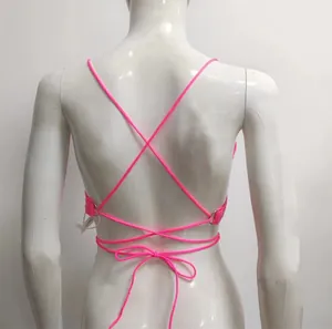Dettaglio posteriore del top bikini rosa neon con paillettes e lacci incrociati