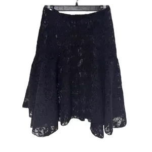 Dettaglio dell'intricato motivo in pizzo nero traforato di una gonna a trapezio