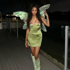 Détail d'une mini robe en satin vert avec broderie florale portée par un mannequin