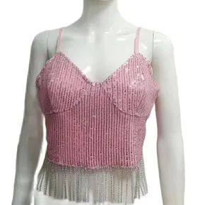 Détail d'un crop top rose à paillettes avec une décoration de franges en chaîne de cristal