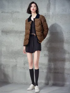 Modische braune gesteppte Leichtjacke mit schwarzem Kragen an asiatischem Model