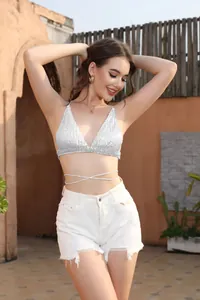 Dettaglio del top bikini sexy con paillettes bianche e lacci incrociati