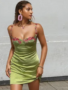 Robe courte élégante en satin vert avocat avec broderies florales et fines bretelles.