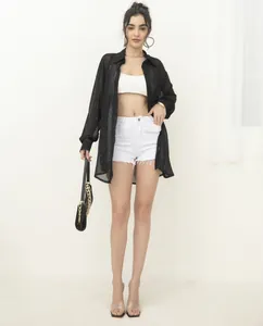 Full body model view of a black long-sleeve sequin sheer shirt with white shorts