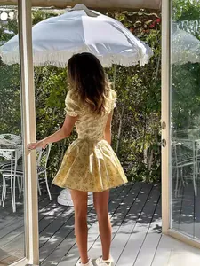 Back view of a French retro yellow floral dress with puff sleeves and puffy skirt.