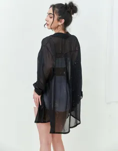 Back view of a black sheer long-sleeved shirt featuring sparkling sequin details