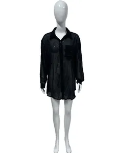 Detail view of a black sheer blouse with sparkling sequins and classic button-down front
