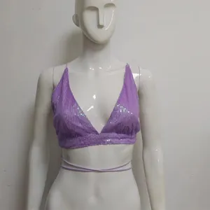 Dettaglio di un top bikini con paillettes viola e allacciatura in vita su manichino