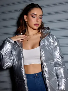 Close-up of a trendy shiny silver oversized puffer jacket with high-shine metallic finish