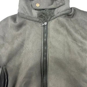 Close-up detail of women's suede jacket showing high-quality zipper and fuzzy collar.