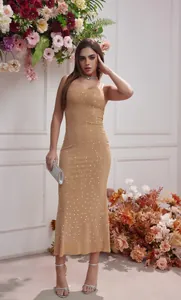 Vista completa de un vestido de gala beige con pedrería y elegantes tirantes finos.
