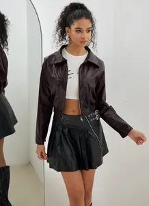 Détail d'une veste courte en cuir PU vintage pour un look de motard élégant.